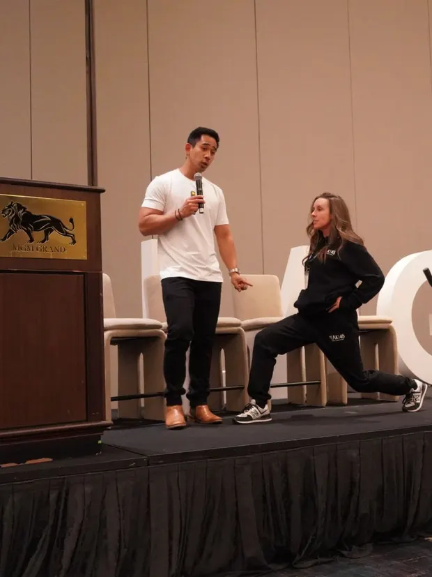 Dr. Rodante Saballa talking through a movement demonstration on stage.